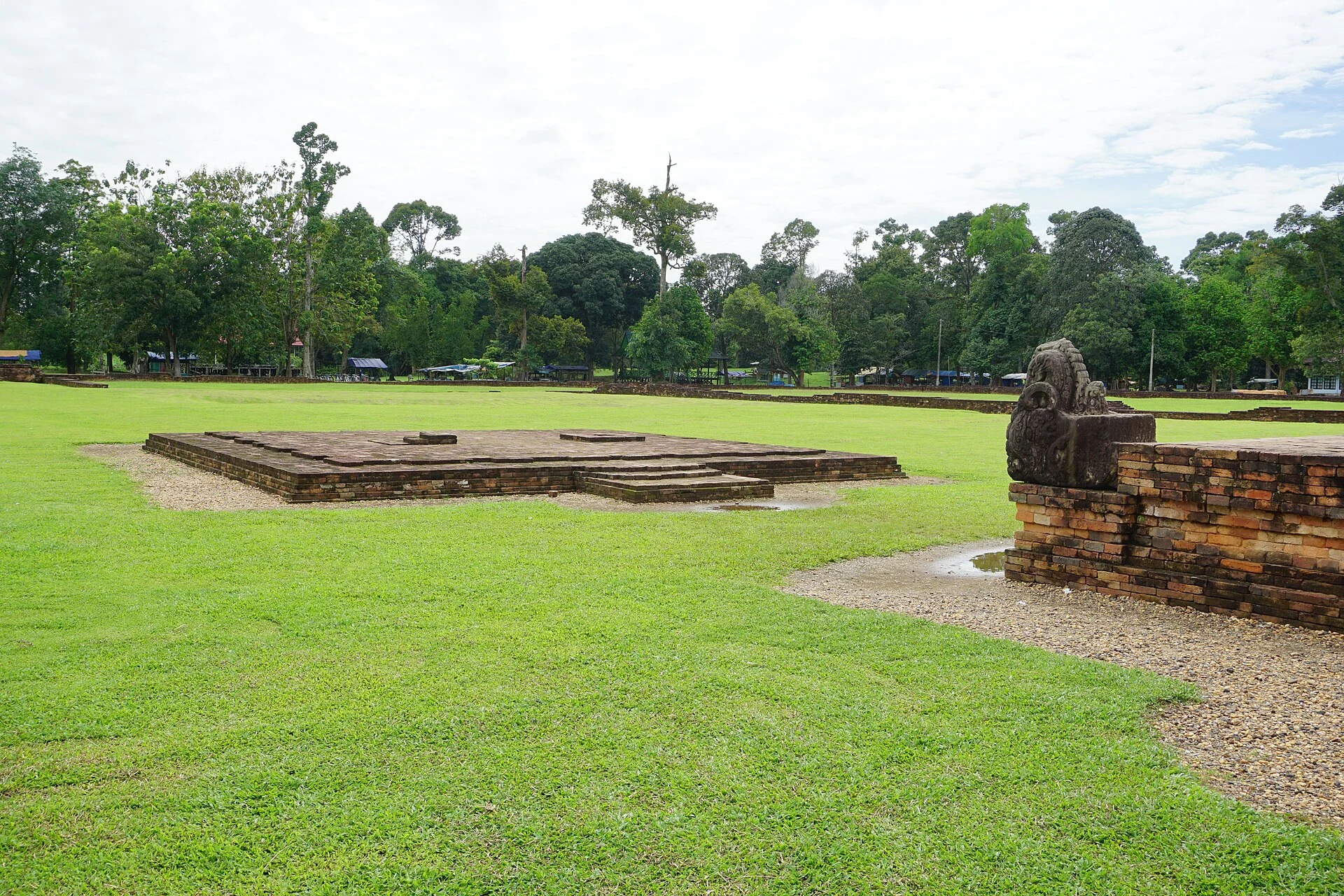 Brick structure of Candi Gumpung among grass and trees at Muara Jambi.