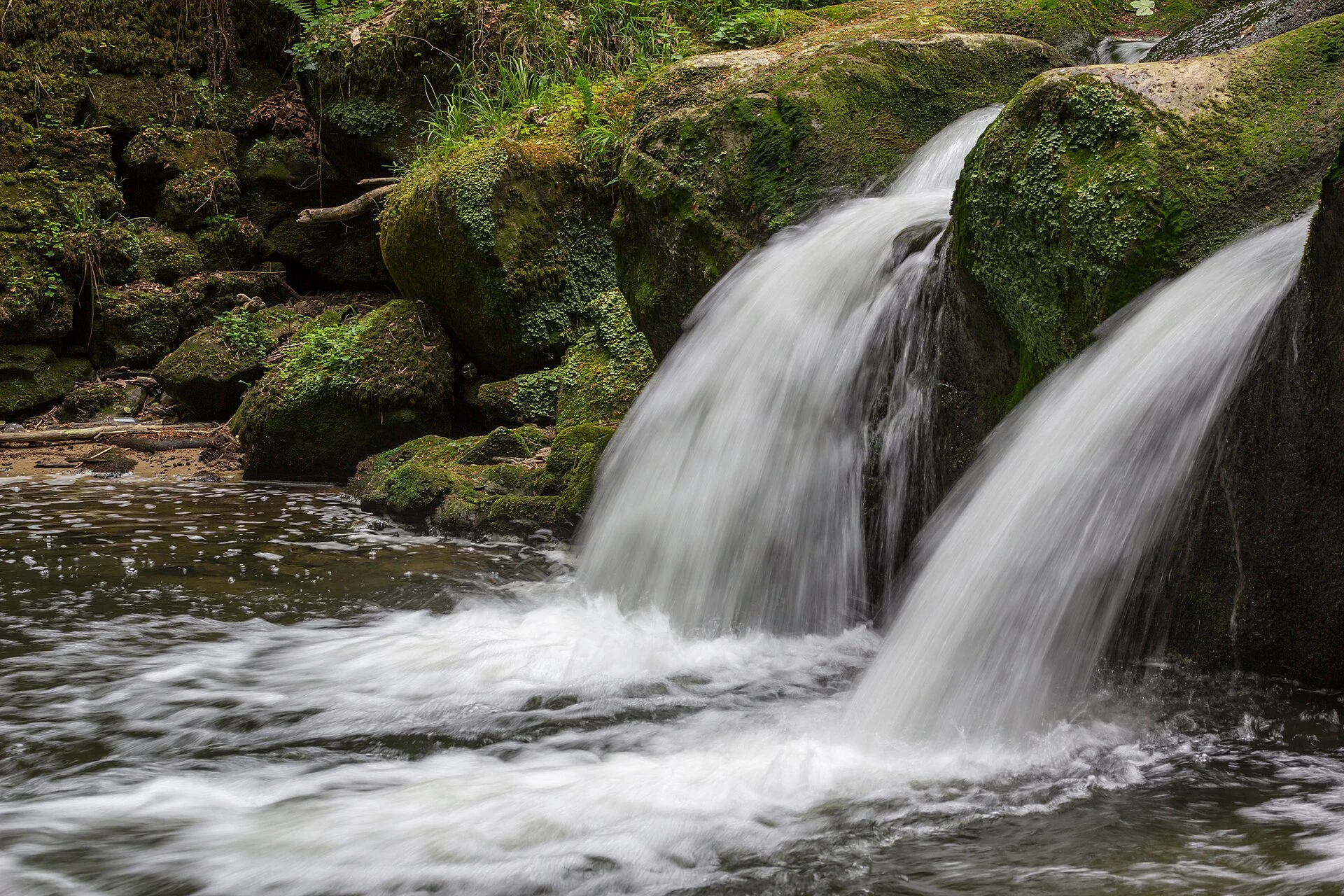 Schiessentümpel waterfall among rocks and forest in Müllerthal, Luxembourg.