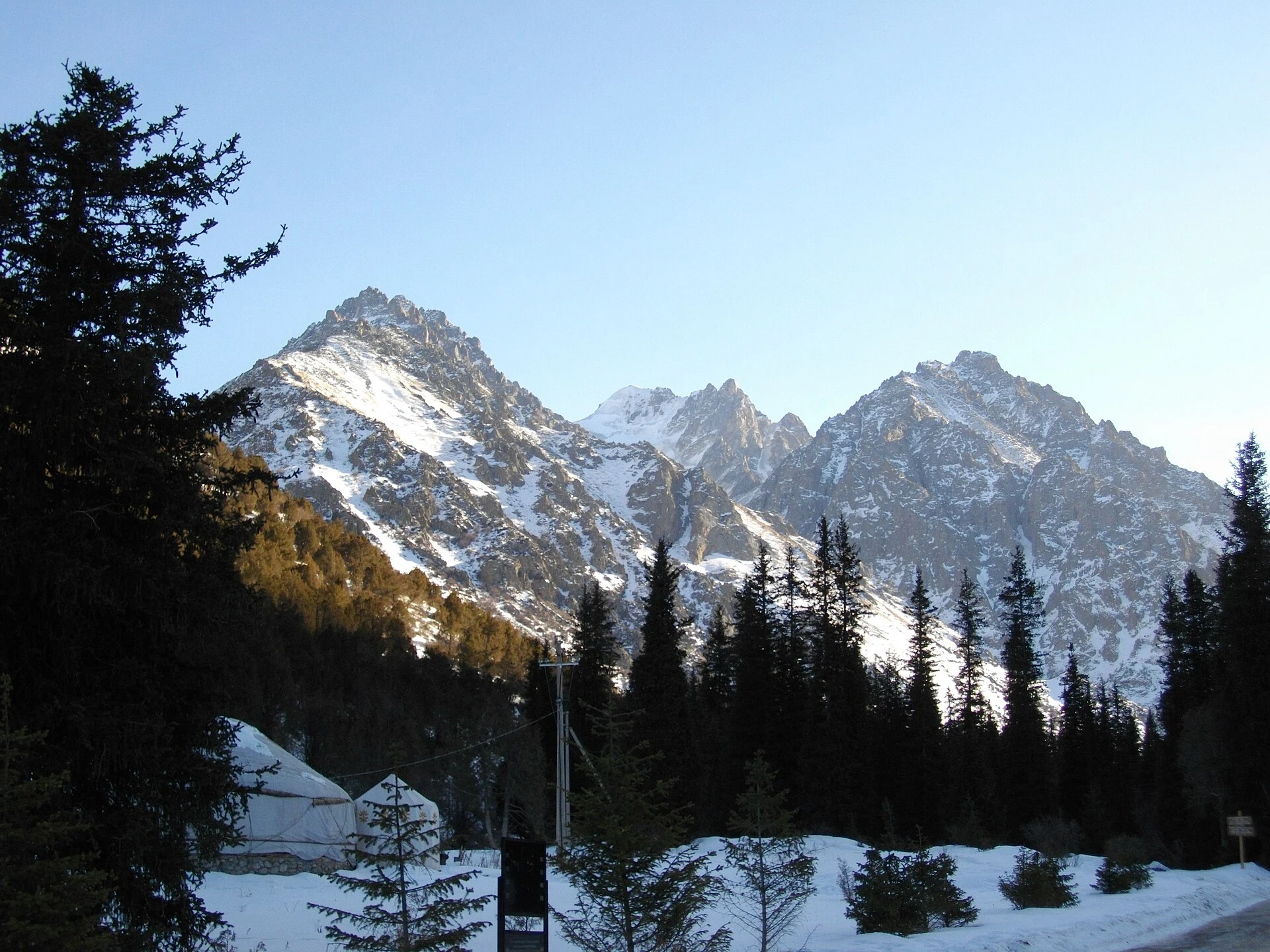 Ala-Archa alpine valley with conifer forest and Tian Shan peaks.