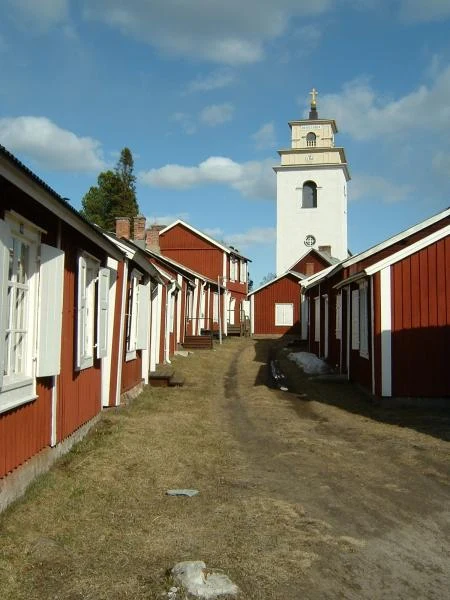Elevated view of red church cottages clustered around Nederluleå Church in Gammelstad.