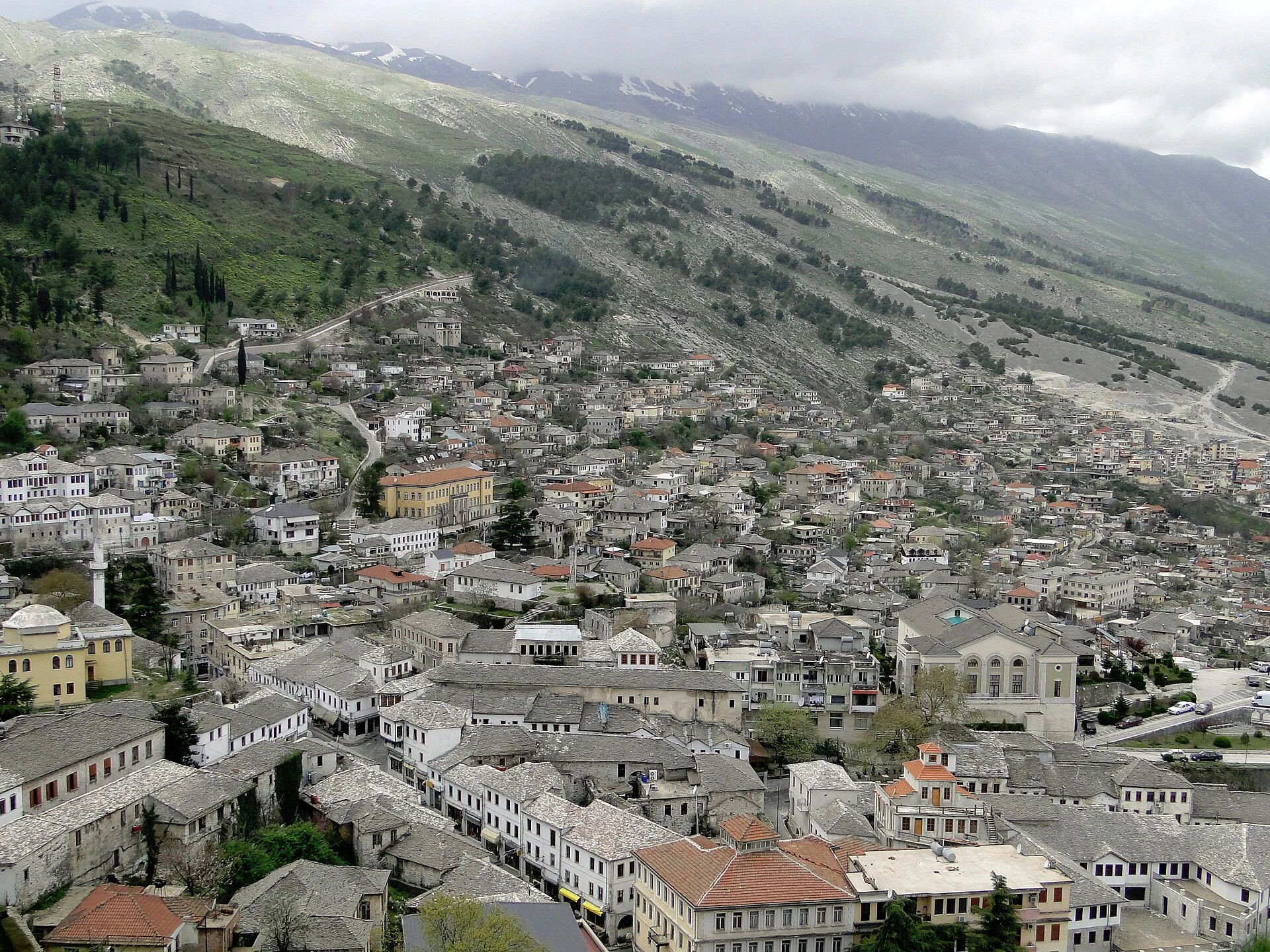 Stone roofs and historic houses of Gjirokastër above the Drino Valley.
