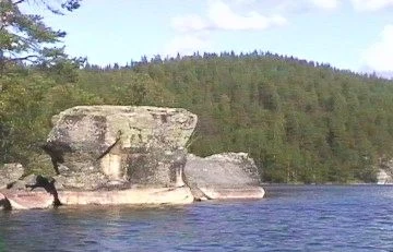 Paddler wearing a life jacket near the cliffs of Kolovesi.