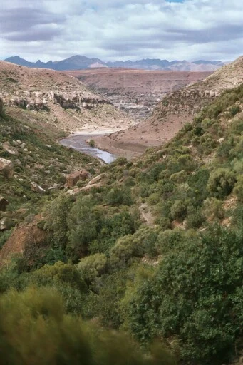 Strada di montagna negli altopiani del Lesotho sotto un cielo variabile.